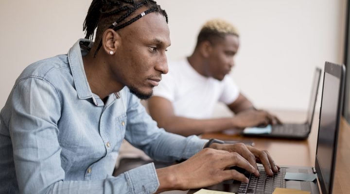 side-view-men-working-laptops-office
